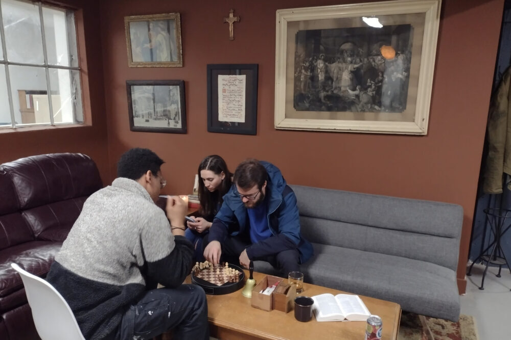 Three people in the The 4:8 Project Coworking space playing chess.